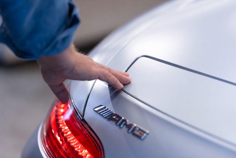 Hand on an AMG Mercedes with an illuminated red taillight